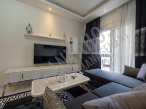 uma sala de estar com um sofá e uma televisão em Calypso Residence in Kestel Alanya E5 em Alanya