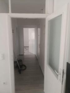 an empty room with a hallway with a window at Apartman Nea in Sanski most