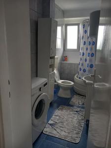 a bathroom with a washing machine and a toilet at Apartman Nea in Sanski most