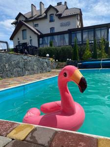 un cisne de plástico rosa flotante en una piscina en Villa Grand en Skhidnitsa