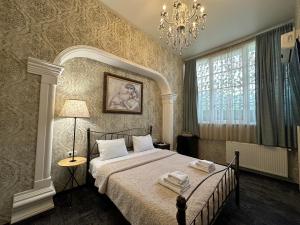 um quarto com uma cama e um lustre em Boutique Hotel Alegria em Tbilisi