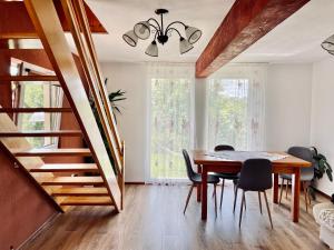 a dining room with a table and chairs and a staircase at Cabana 7 Brazi in Poiana Mărului