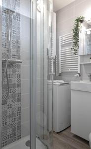 une salle de bain avec douche et lavabo dans l'établissement Woody 100m du lac balcon, à Annecy