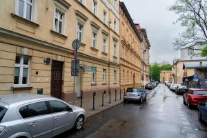 une rue avec des voitures garées sur le côté d'un bâtiment dans l'établissement Studio Asnyka Old Town, à Cracovie