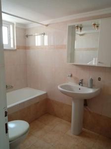 a bathroom with a sink and a tub and a toilet at Alasrooms Γ1 in Missolonghi +28 photos