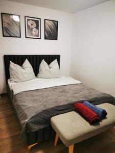 a bed with white pillows and a bench in a room at Under the Hill 1 in Bad Muskau