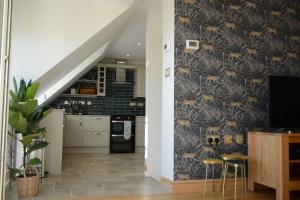 a kitchen with a wall with a blue and gold wallpaper at Field View in Braunston