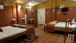 a room with two beds and a table with a television at Wild Dunes Konark in Bālighāi