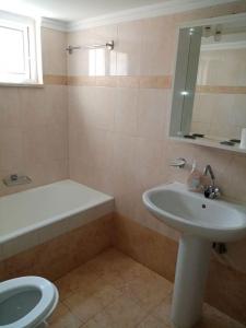 a bathroom with a sink and a toilet and a mirror at Alasrooms A1 in Missolonghi +21 photos