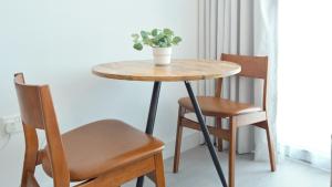 a table with two chairs and a potted plant on it at Delightful Staycation in Masdar in Al Qurayyah