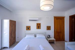 a bedroom with a large white bed in a room at Sole'n Blu in Kaş