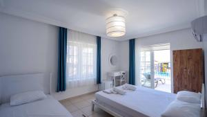a bedroom with two beds and a view of a patio at Sole'n Blu in Kaş