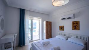 a bedroom with a bed and a desk and a window at Sole'n Blu in Kaş
