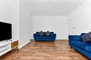 a living room with two blue couches and a tv at 3BR home/Fast Wi-Fi/ Quiet road in Hither Green