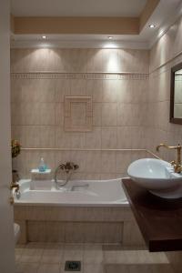 een badkamer met een bad en een wastafel bij Αλσύλλιο - Alsillio studio apartments in Ierissos