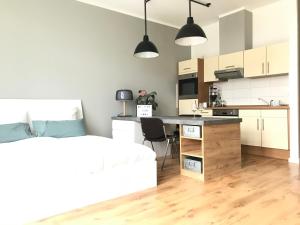 ein Schlafzimmer mit einem Bett und eine Küche mit einem Schreibtisch in der Unterkunft Charmantes Loft mit Balkon in Magdeburg