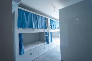 a room with two bunk beds with blue curtains at Sole'n Blu in Kaş