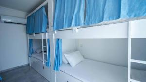 a room with two bunk beds with blue curtains at Sole'n Blu in Kaş