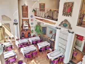 イスタンブールにあるオリエント ミントゥール ホテルの白いテーブルと紫色の椅子が備わるレストラン