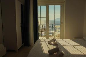 a bedroom with a bed with a view of a balcony at Sole'n Blu in Kaş