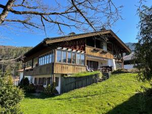 a house on top of a grassy hill at Ferienhaus am Hochgern in Unterwössen