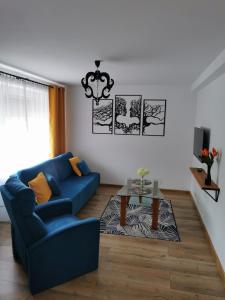ein Wohnzimmer mit einem blauen Sofa und einem Tisch in der Unterkunft Under the Hill 1 in Bad Muskau
