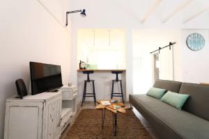 a living room with a couch and a flat screen tv at duArteLoft in Sines