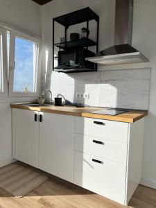 a white kitchen with a counter and a window at Ático casa de invitados Bluemoon in Las Lagunas