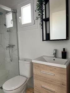 een badkamer met een toilet, een wastafel en een spiegel bij Ático casa de invitados Bluemoon in La Laguna