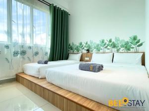 two beds in a room with green curtains at Amber Cove Impression City Melaka City Center 8 min to Jonker Street in Melaka