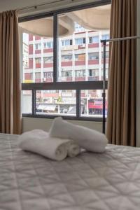een bed in een kamer met een groot raam bij Sunny studio apartment in Thessaloniki city center in Thessaloniki