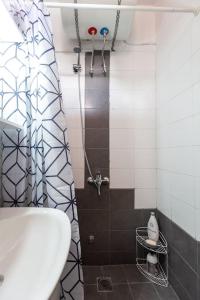 La salle de bains est pourvue d'une douche, d'un lavabo et de toilettes. dans l'établissement Sunny studio apartment in Thessaloniki city center, à Thessalonique