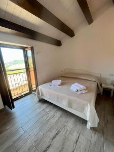 a bedroom with a bed and a large window at Vianova in Pietrapertosa
