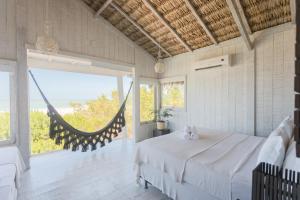 a bedroom with a bed and a large window at Beach Houses Moitas in Amontada