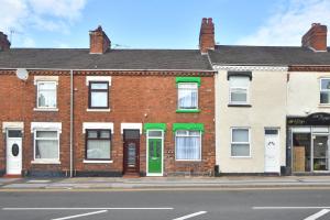 a brick building with a green door on a street at GREEN DOOR in Etruria