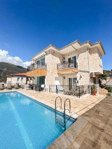 a large house with a swimming pool in front of it at Sole'n Blu in Kaş