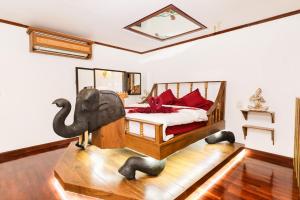 1 dormitorio con 1 cama con silla de elefante en Olivier Boutique, en Chiang Mai