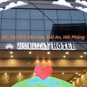 a sign on a building with a heart on top at Holiday Hotel in Hai Phong