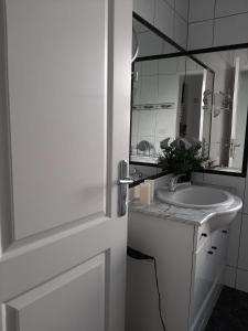 Un baño blanco con lavabo y espejo. en An oasis of relaxation. Feel good - enjoy!, en Santiago del Teide