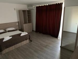 a bedroom with a bed and a red curtain at Vila Davi in Costinesti +29 photos