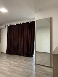 Habitación con cortina marrón y espejo. en Vila Davi en Costinesti