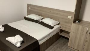 a bedroom with a large bed with white sheets and pillows at Vila Davi in Costinesti