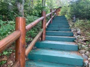 a wooden stairway leading up to a house at The croquet cabin your year round romantic escape in Boulder Junction