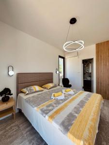 a bedroom with a large bed with yellow towels on it at Adriatic Dream in Tivat