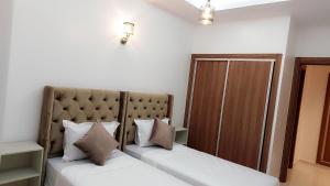 a bedroom with two beds and a mirror at Appartement Costa Bouznika in Bouznika