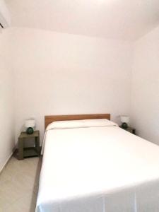 ein weißes Bett in einem Zimmer mit zwei Nachttischen in der Unterkunft Corallo costa dei trabocchi in Torino di Sangro