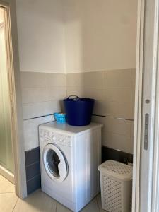 eine Waschmaschine mit einem blauen Eimer darüber in der Unterkunft Corallo costa dei trabocchi in Torino di Sangro