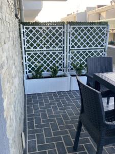 a patio with two chairs and a fence with plants at Corallo costa dei trabocchi in Torino di Sangro +3 photos