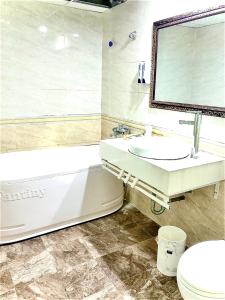 a bathroom with a tub and a sink and a toilet at Holiday Hotel 2 in An Khê