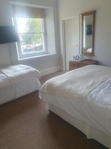 a hotel room with two beds and a window at The Shrubbery Hotel in Shepton Mallet